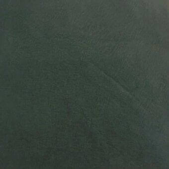 Rugiano indoor rug, dark green leather with aniline cashmere finish, textured surface displaying irregular lines and a matte appearance.